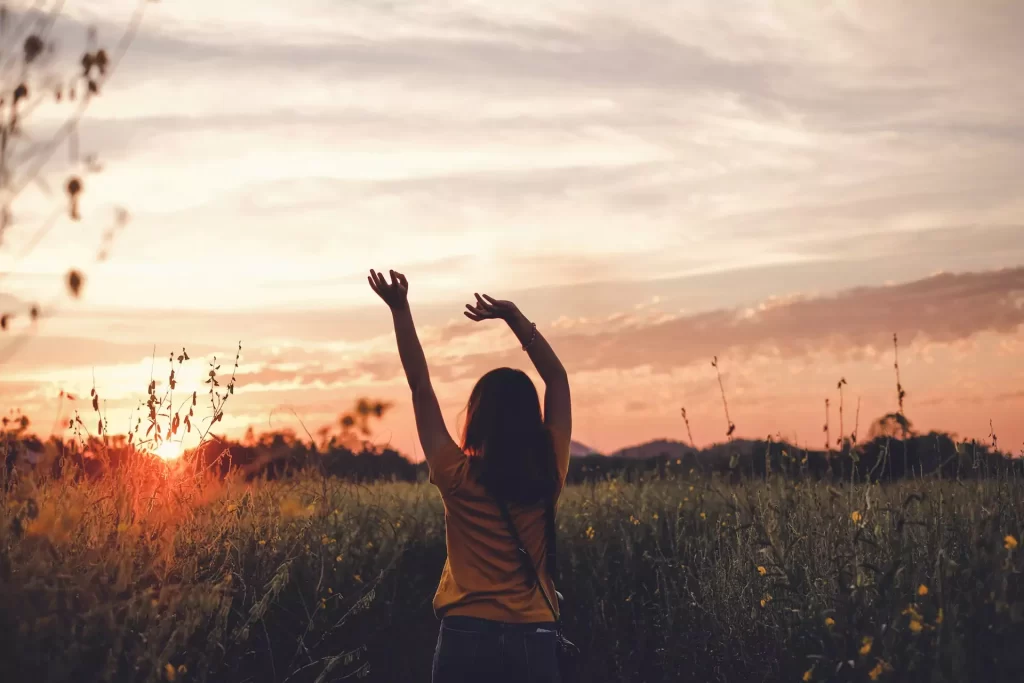 Scriptures for addiction: concept pic shows woman swaying arms in the grassland